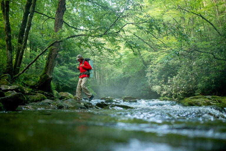 hiker crossing a stream