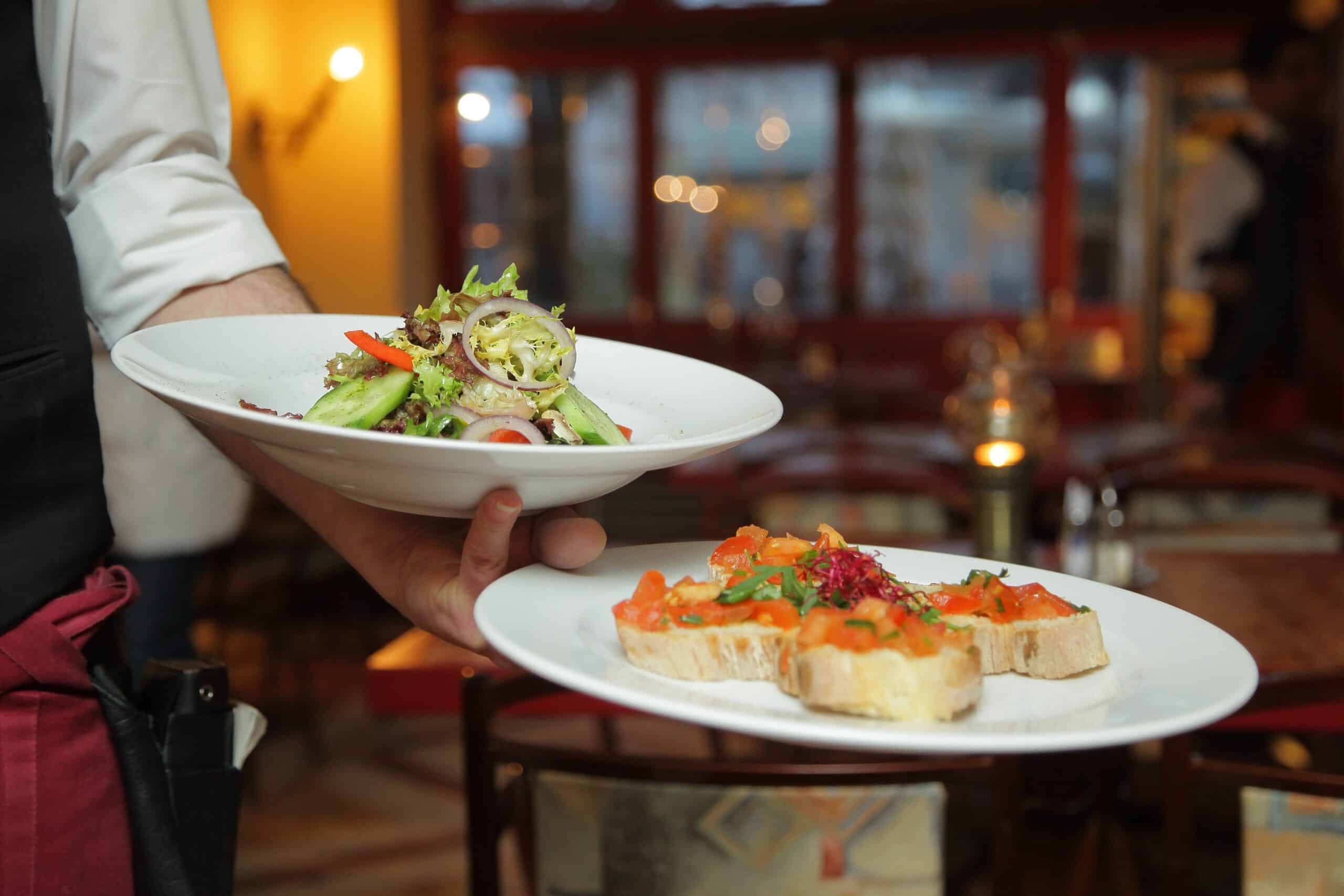 waiter balancing two plates of food