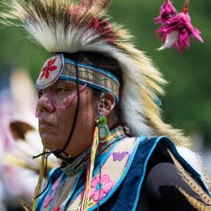 performers wearing vibrant traditional attire perform a dance at a 4th of July powwow, while spectators watch.