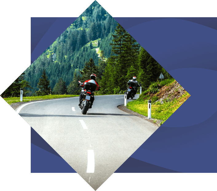 two people Motorcycling in NC on road with mountain in background